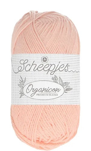 A 50g ball of Scheepjes Organicon yarn in a soft pastel shade, showcasing its smooth matte finish and 100% organic cotton texture in peach colour