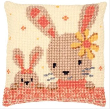 A Vervaco needlepoint kit featuring the 'Sweet Bunnies' design. The image shows two adorable, fluffy bunnies in a soft-focus garden setting. The kit includes a large-hole Zweigart canvas with the design hand-painted on the intersections, vibrant acrylic yarn, and a tapestry needle, designed to be finished as a 40cm decorative pillow cover.