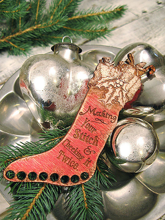 A professional-grade wooden floss organizer shaped like a classic vintage Christmas stocking. This high-definition tool is crafted from premium local hardwoods in the USA. It features 8 precision-drilled holes along the top of the stocking for sorting embroidery floss and a charming, laser-etched vintage holiday design.