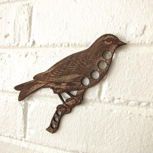 A professional-grade wooden floss organizer shaped like a charming vintage songbird. Crafted in the USA from premium local hardwoods, this high-definition tool features 7 precision-drilled holes along the bird's silhouette for thread organization.
