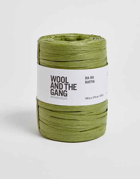 A roll of grass green Wool And The Gang Ra-Ra Raffia yarn with a label in the center.