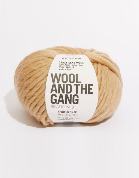 A giant 200g ball of Wool and the Gang Crazy Sexy Wool, showcasing its thick, plump, and ultra-soft 100% Peruvian wool fibers in blonde beige