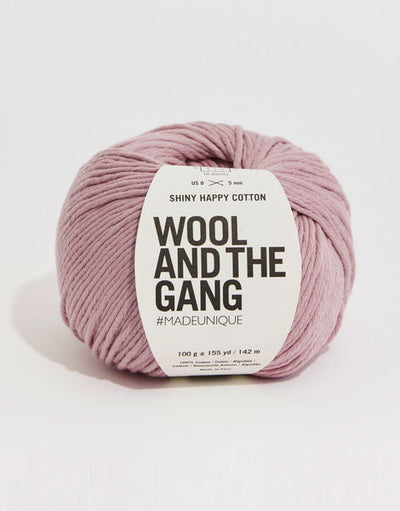 A 100g ball of Wool and the Gang Shiny Happy Cotton yarn in a vibrant mauve shade, showing its smooth texture and subtle natural sheen. Best Cotton Yarn for Summer, Luxury Aran Cotton, WATG Yarn Singapore.