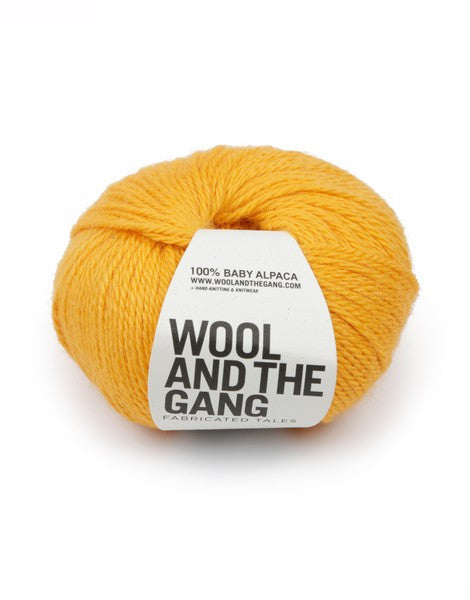 A blue skein of WOOL AND THE GANG Sugar Baby Alpaca yarn with a label in the center in yellow orange colour