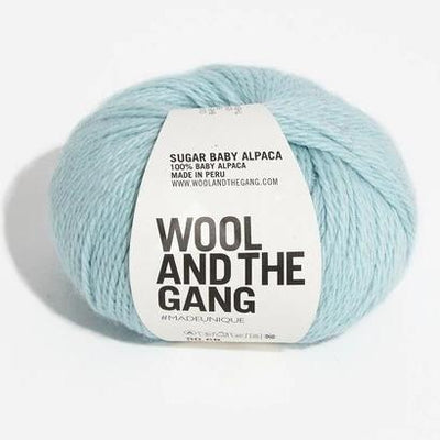 A blue skein of WOOL AND THE GANG Sugar Baby Alpaca yarn with a label in the center in light sky blue colour