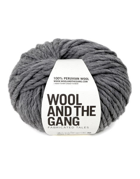 A bold red ball of Wool and the Gang Crazy Sexy Wool yarn with a label in the center against a white background in tweed grey colour.