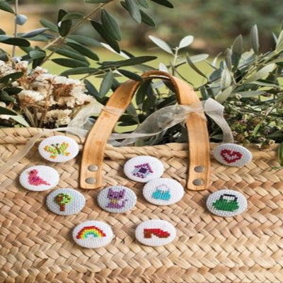 Showing various small cross stitch motifs from small floral motifs to hearts and rainbow from the 300 Ideas book, demonstrating its upcycling potential.