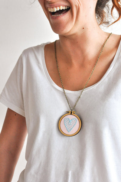 A person wearing the 5cm mini hoop showcasing the teeny-tiny scale and smooth wooden finish