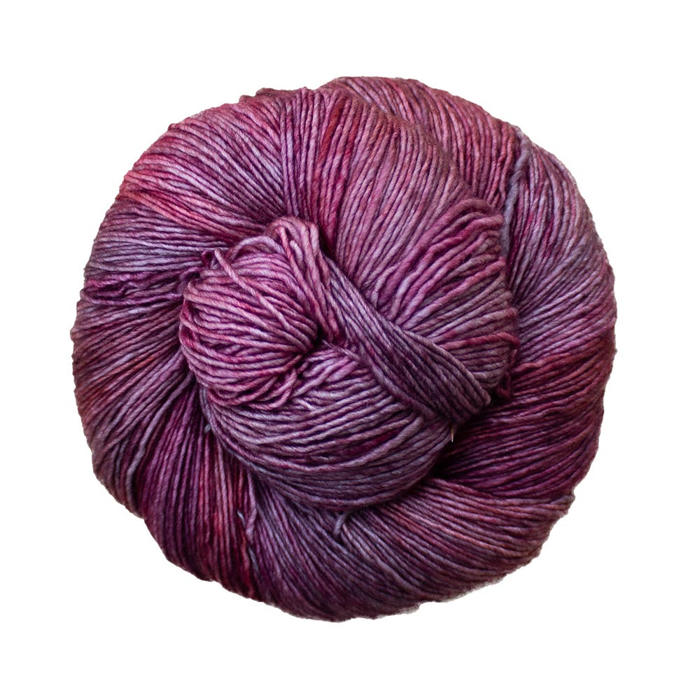 A skein of Malabrigo Mechita yarn in a purple and pink hand-dyed color.