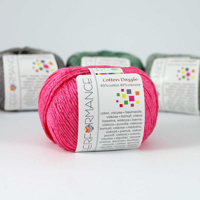 A 50g skein of Cotton Dazzle yarn in shocking pink a vibrant shade, showcasing the subtle reflective shimmer and smooth plied texture of the cotton-viscose blend